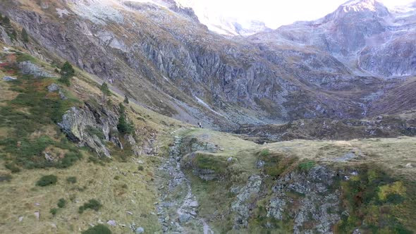 Two hikers at Val d'Arrouge ridge stone path leading to Lac d'Espingo in Haute-Garonne, Pyrénées, Fr