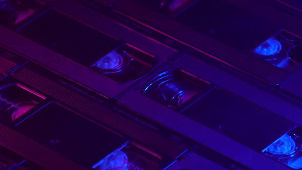 Retrofuturistic background of VHS cassettes sliding up, blue and purple lighting