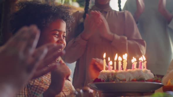 Happy African American Kid Blowing Candles on Birthday Cake