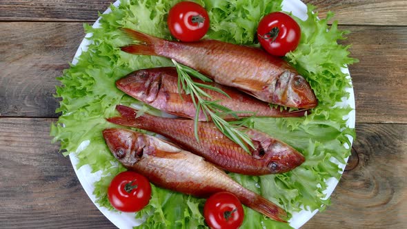 Smoked Whole Sea Fish Served Salad Leaves with Tomato and Rosemary Rotate Slowly on White Dish