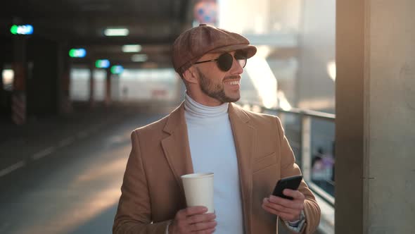 Always in Touch. Handsome Young Man Is Holding and Using Mobile Phone App, Bearded Businessman User
