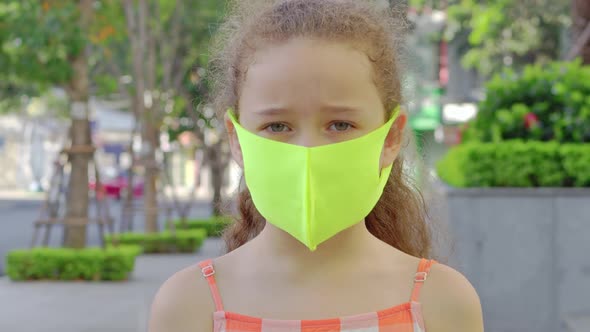 Pandemic Portrait of Little Girl Wearing Protective Mask on Street in City