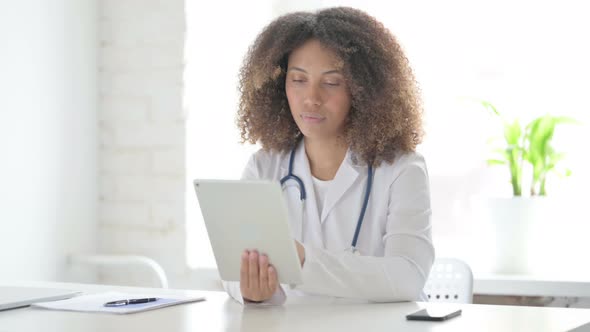 Afrcian Doctor using Tablet while Sitting in Clinic