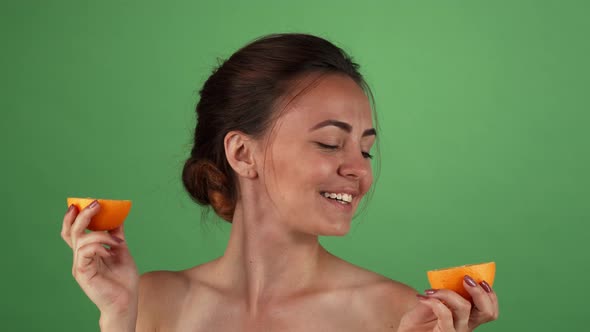 Gorgeous Happy Female Smiling Holding Oranges on Green Chromakey