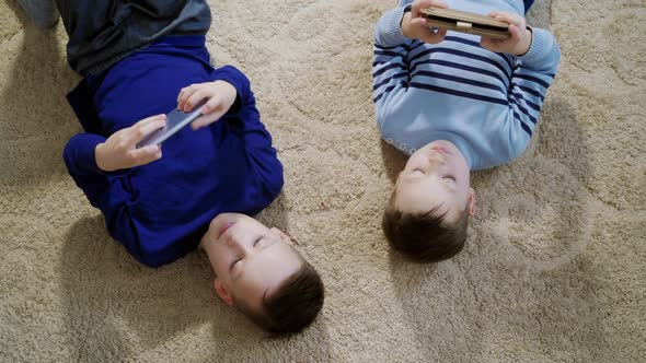 Little boys playing game on mobile together. Child playing video game at home