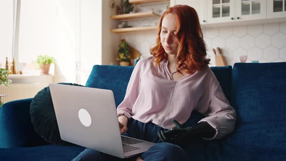 Redhaired Girl with an Unusual Appearance Who Has a Modern Prosthesis on Her Left Hand