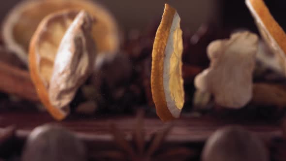 Lemon Slice and Ginger Falling Among Spices on Wood