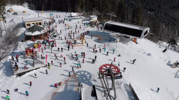 Aerial View Crowd of Skiers Skiing on Peak Ski Slope Near Ski Lifts. Ski Resort