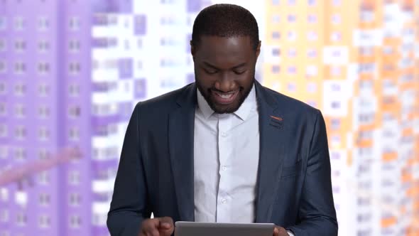 Smiling Black Businessman Using Computer Tablet.