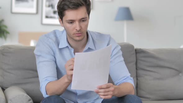 Excited Handsome Young Man Cheering While Reading New Contract