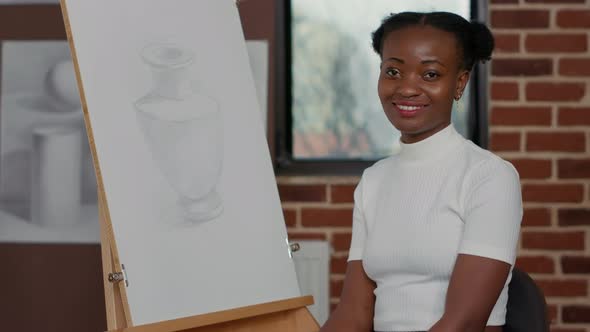 Portrait of Creative Woman Sitting in Front of Canvas with Drawing