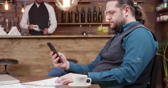 Man Working on His Computer From a Restaurant