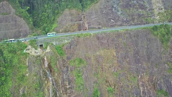 Flycam Shows Bus on Road Over Cliff with Beautiful Waterfalls
