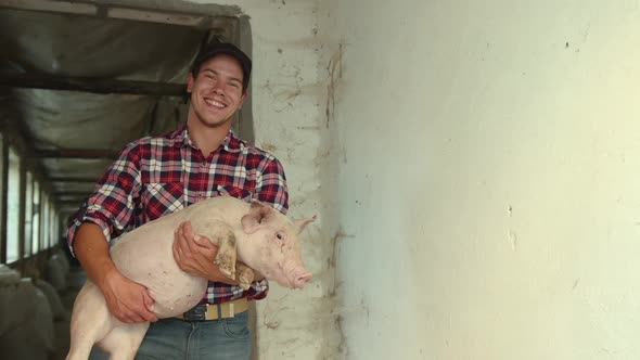 The Farmer is Holding a Heavy Piglet