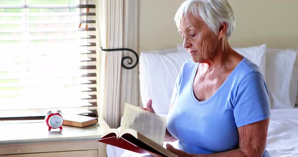 Senior woman reading a book in the bedroom