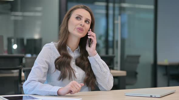 Young Businesswoman Talking on Smartphone at Work