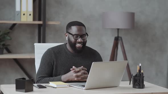 Black Guy Waves His Hand Into a Laptop and Communicates Via Video Link with Loved Ones in Casual