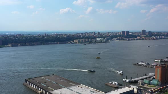Aerial footage of several ferry boats docking at a pier on the Hudson River, viewed from the New Yor