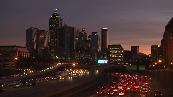 Static, wide shot of the Atlanta Skyline at night with traffic flowing below.