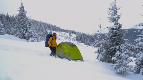 A Man with a Backpack Travels in the Winter Mountains