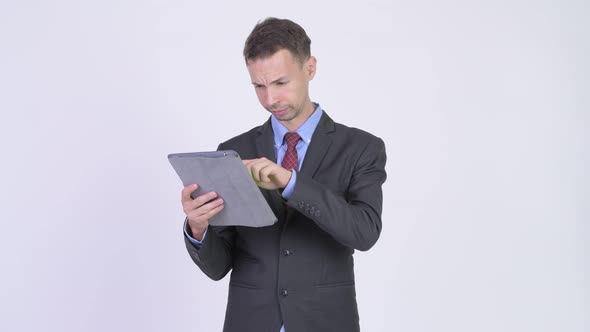 Studio Shot of Happy Businessman Using Digital Tablet and Getting Good News