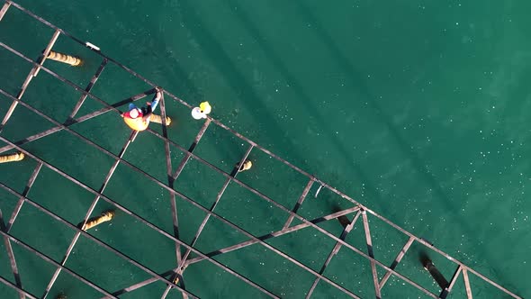 A fisherman catches fish on an old pier