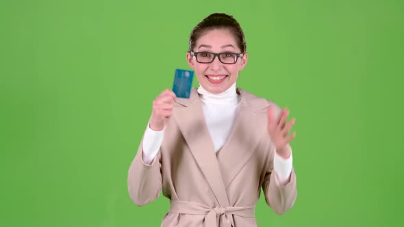 Woman with a Bank Card Is Rich and Happy with the Win. Green Screen