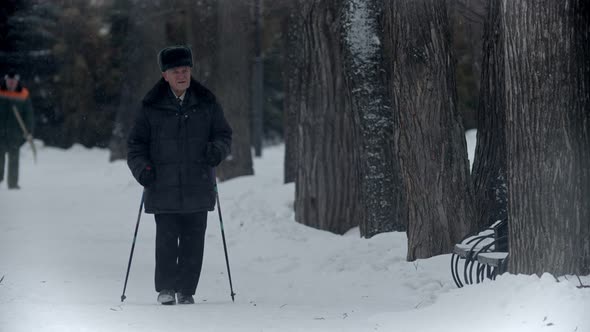 Elderly Grandfather - Happy Grandfather Is Engaged in Nordic Walking in a Winter Park