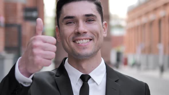 Outdoor Thumbs Up By Young Businessman