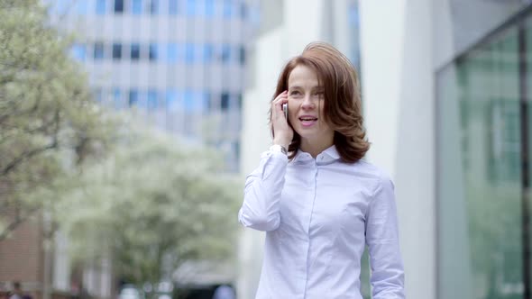 Business Woman makes a call whislt standing outside the office