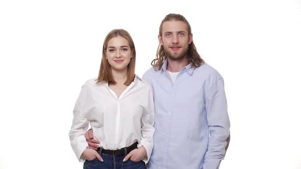 Young Caucasian Couple Huging and Smiling on White Background