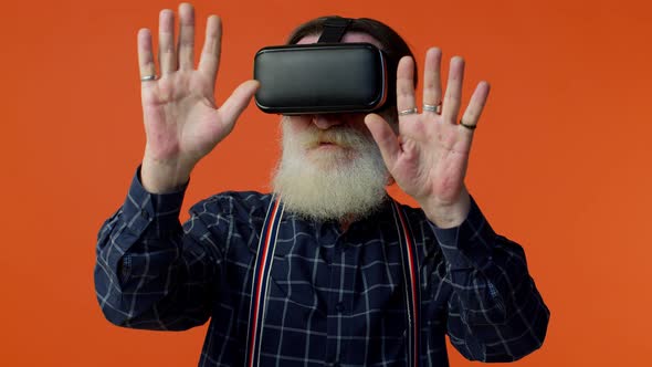 Senior Stylish Grayhaired Man Using Headset Helmet App to Play Simulation Virtual Reality VR Game