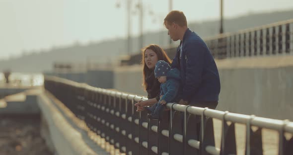 Korean Woman and Her Husband Are Standing on the Riverbank Near the Parapet and Talking