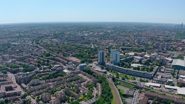 Descending drone shot of British rail train passing through residential south London