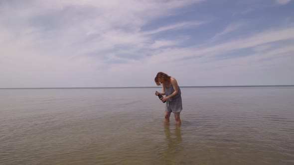 Happy Young Woman Shaking and Opening Bursting Champagne in the Middle of Sea