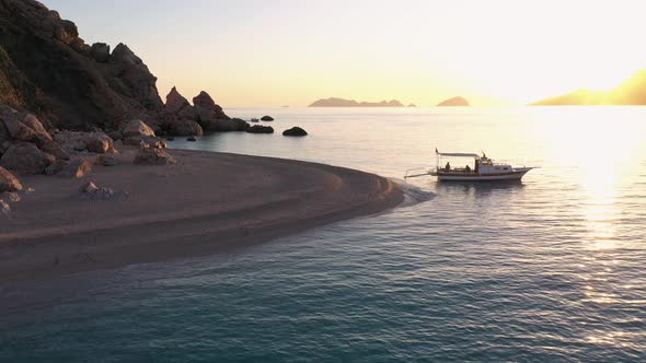 Wild Rocky Beach and Parked Boat at Sunset