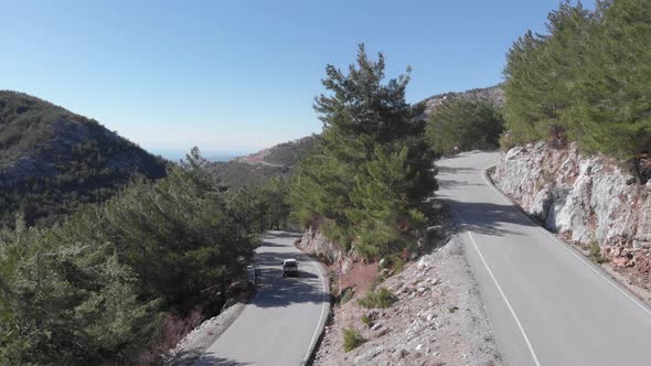 Car driving down from mountain pass.