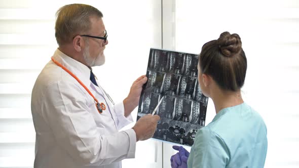 Two Doctors Examining X-ray Images of Patient for Diagnosis.