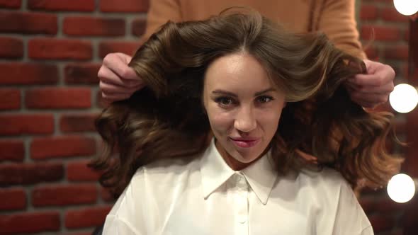 Front View Young Woman Satisfied with New Hairdo Looking at Camera Smiling As Man Adjusting Hair