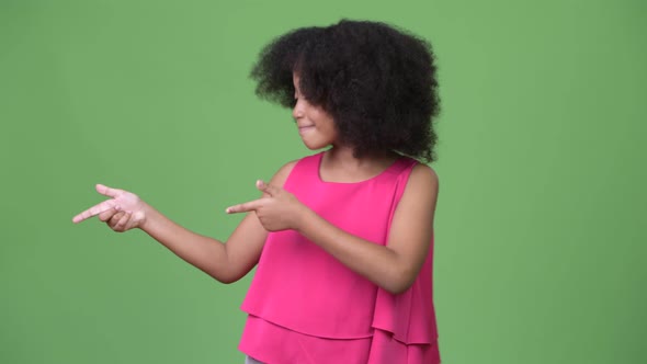 Young Cute African Girl with Afro Hair Showing Something