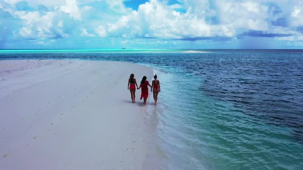 Ladies together enjoying life on beautiful seashore beach voyage by blue lagoon and white sand backg