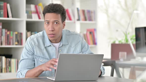 Working Young African American Man in Shock Looking at Camera