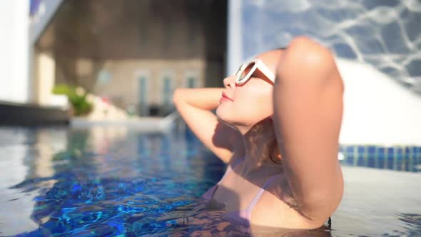 Young asian woman enjoy around outdoor swimming pool for leisure