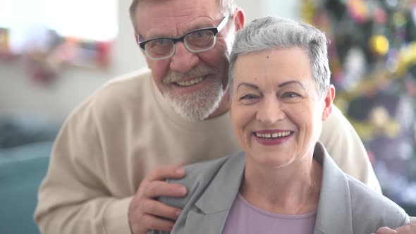 Close Portrait of Smiling Elderly Husband and Wife Looking at Camera