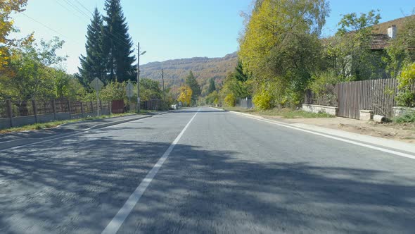 On the Road, View From Drone. Peaceful Asphalt Road in Bulgarian Village in the Autumn