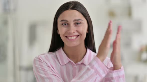 Portrait of Excited Young Latin Woman Clapping