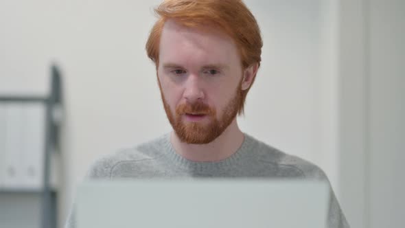 Portrait of Redhead Man Celebrating While Using Laptop 