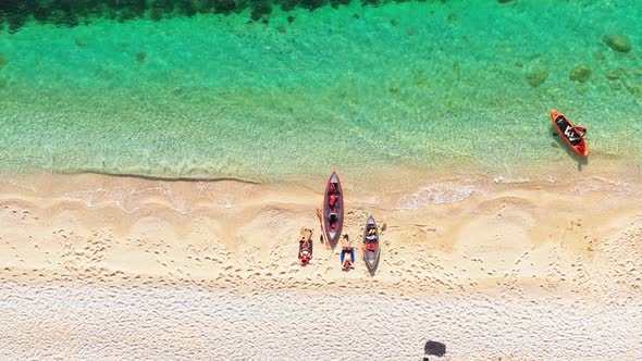 Aerial Top View of a Couple Laying on the Beach After Summer Sport