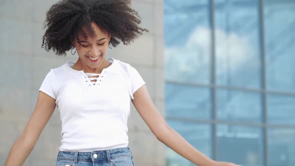 Active Young American Ethnic Woman Jumping Dancing in City Street, Outdoors. Happy Student Girl