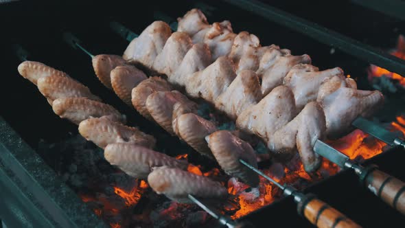 Chicken Wings on Skewers Is Cooked on Barbecue at Street Food Festival
